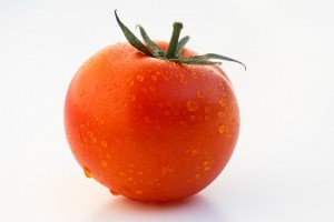 A fresh tomato - called pomodoro in Italian - against a white background.