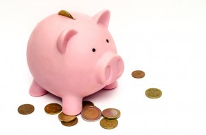 A piggy bank surrounded by European coins.