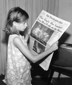 A young girl holding a copy of The Washington Post from the day after the first moon landing in 1969.