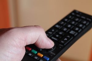 A closeup of a man's hand holding a remote control.