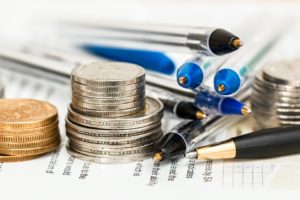 Coins and pens stacked on a lease agreement.